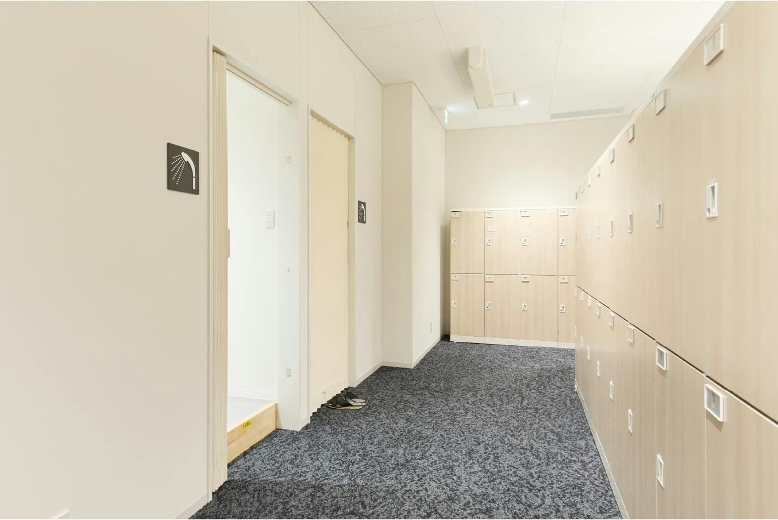 日東電工株式会社 様の事例写真／[1F 更衣室]作業を終えた従業員が、着替える前にシャワーを使えるようになりました。私服通勤導入に伴い、さらに働きやすい環境が整備されています。